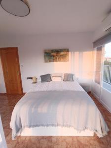 un letto bianco in una camera da letto con finestra di California Suite - All-day Sunny 2-Bedroom Apartment a El Campello