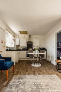 a living room with a table and a kitchen at Stillness- Connect to the Nature in the Hot Tub in Blandford Forum