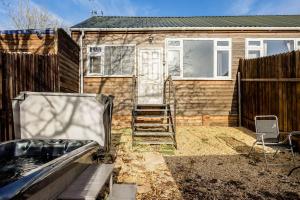 a home with a fence and a house at Stillness- Connect to the Nature in the Hot Tub in Blandford Forum