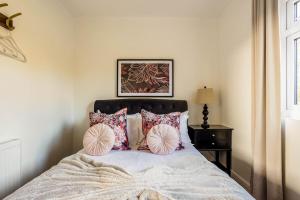 Un dormitorio con una cama con almohadas. en Stillness- Connect to the Nature in the Hot Tub en Blandford Forum