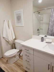 a white bathroom with a toilet and a sink at Modern Downtown SLC Apartment in Salt Lake City