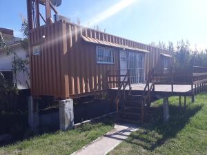 una pequeña casa con una escalera en un patio en dto. conteiner con vista al mar 50mts y playa, en Santa Clara del Mar