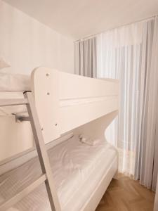 ein weißes Etagenbett mit einer Leiter in einem Zimmer in der Unterkunft Diamond Apartment Prishtina 2 in Pristina