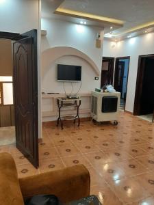 - un salon avec une télévision, un canapé et une table dans l'établissement City Center Guest house and Hostel, à Assouan