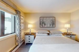 two beds in a bedroom with two lamps and a window at Mountain's Edge in Brownsville