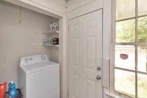 a laundry room with a white door and a washing machine at Stylish 3 bedroom home close to downtown Mobile in Mobile