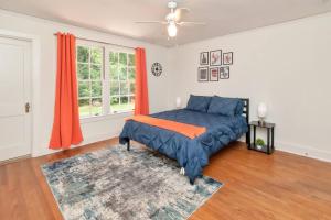 a bedroom with a bed and a window with orange curtains at Stylish 3 bedroom home close to downtown Mobile in Mobile