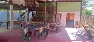 a patio with tables and chairs on a house at HOSPEDARIA pingo d ouro Cunca in Atins