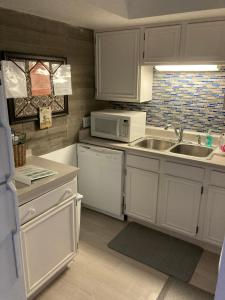 kuchnia z białymi szafkami, zlewem i kuchenką mikrofalową w obiekcie Lakeside Condo with plenty of amenities close to Bristol Mountain - permit - 2024-0018 w mieście Canandaigua