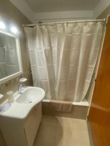 y baño con cortina de ducha y lavamanos. en Avenida Corrientes y Billinghurst a metros de Abasto Shopping en Buenos Aires