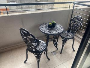 2 sillas y una mesa con una planta en el balcón en Avenida Corrientes y Billinghurst a metros de Abasto Shopping en Buenos Aires