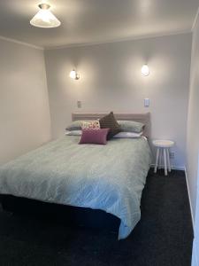 a bedroom with a large bed and a table at St Andrews Unit in Hamilton