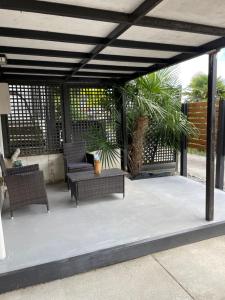 a patio with two wicker chairs and a table at St Andrews Unit in Hamilton