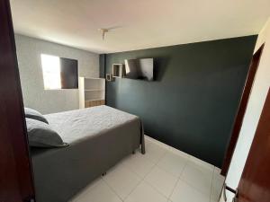 1 dormitorio con cama y pared verde en Apart 302 no José Américo, en João Pessoa