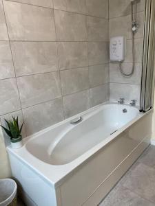 a white bath tub in a bathroom at Glengesh Court. Ardara town centre. in Ardara