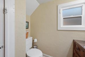 a bathroom with a toilet and a window at Garden City House with Hot Tub in Colorado Springs +46 photos