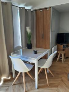 una mesa blanca y sillas en una habitación con TV en Chalet DIE SONNE en Oostkapelle