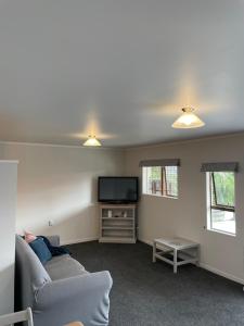 ein Wohnzimmer mit einem Sofa und einem Flachbild-TV in der Unterkunft St Andrews Unit in Hamilton