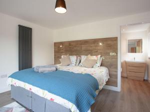 a bedroom with a large bed with a wooden headboard at Kingfisher Lodge - Uk33889 in Cullompton