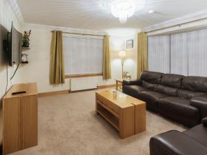 a living room with a leather couch and a coffee table at Agincourt in Invergordon