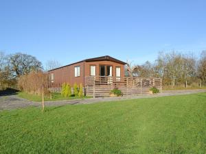 una pequeña casa de madera en un campo con patio en Watches - Uk13544, en Bassenthwaite