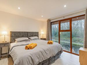 a bedroom with a large bed with two yellow pillows on it at Waterside Lodge Four - Uk36706 in Southowram