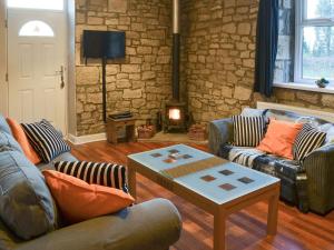 a living room with two couches and a coffee table at Stable Cottage - Uk3285 in Guyzance