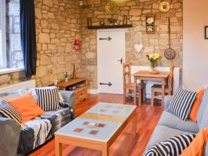 a living room with two couches and a table at Stable Cottage - Uk3285 in Guyzance