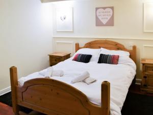 a bedroom with a wooden bed with two towels on it at Stable Cottage - Uk3285 in Guyzance