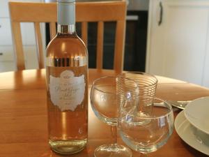 een fles wijn naast twee glazen op een tafel bij The Courtyard Suite in Oathlaw