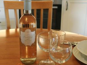 a bottle of wine next to two glasses on a table at The Courtyard Suite in Oathlaw