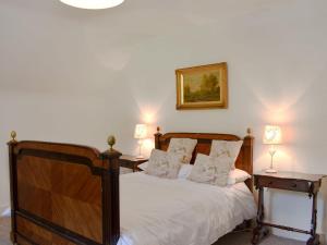 a bedroom with a wooden bed with two night stands at The Courtyard Suite in Oathlaw