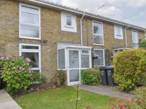 a brick house with white windows and a yard at Stone Gardens in Broadstairs