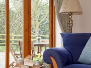 a living room with a blue couch and a window at Cowslip Cottage in Brook