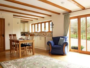 a living room with a blue chair and a table at Cowslip Cottage in Brook