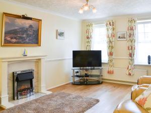 a living room with a television and a fireplace at Jackdaw House in Bridlington