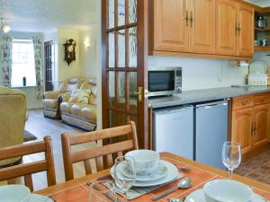uma cozinha e sala de estar com mesa e cadeiras em Jackdaw House em Bridlington