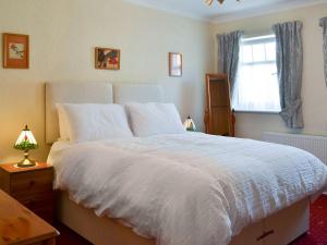 um quarto com uma grande cama branca e uma janela em Jackdaw House em Bridlington