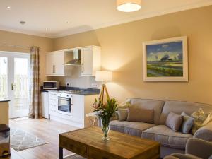 een woonkamer met een bank en een tafel bij Craigmore View-uk34220 in Aberfoyle