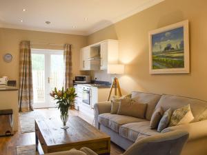 ein Wohnzimmer mit einem Sofa und einem Tisch in der Unterkunft Craigmore View-uk34220 in Aberfoyle