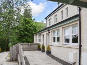 una casa blanca con una valla y un patio en Craigmore View-uk34220, en Aberfoyle