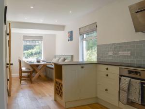 a kitchen with a table and a dining room at Speedwell Cottage in Woodgreen