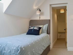 a bedroom with a bed with a blue pillow on it at Speedwell Cottage in Woodgreen