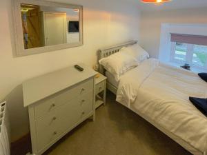 sypialnia z łóżkiem i komodą z lustrem w obiekcie Palm Cottage w mieście Saint Day