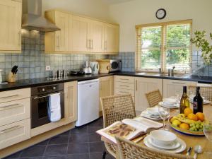 Len Cottage في Thurning: مطبخ مع طاولة عليها صحن فاكهة