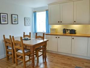 cocina con mesa de madera, mesa y sillas en Havannah Cottage en Alnham