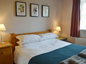 a bedroom with a bed and three pictures on the wall at Havannah Cottage in Alnham