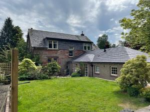 an old brick house with a green yard at The Bield in Aberfoyle