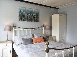 um quarto com uma cama e duas fotografias na parede em 3 Winville Mews em Askrigg