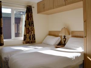 two twin beds in a bedroom with a window at Lodge E- Uk33091 in Dinnet
